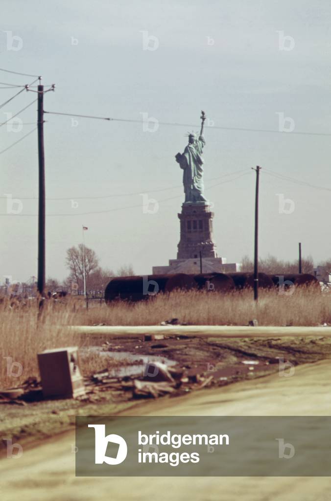 Statue of Liberty seen from the dump in New Jersey that will become Liberty State Park that opened June 14 1976 and is now a popular site where ambitious politicians kickoff presidential campaigns. c. 1973-75