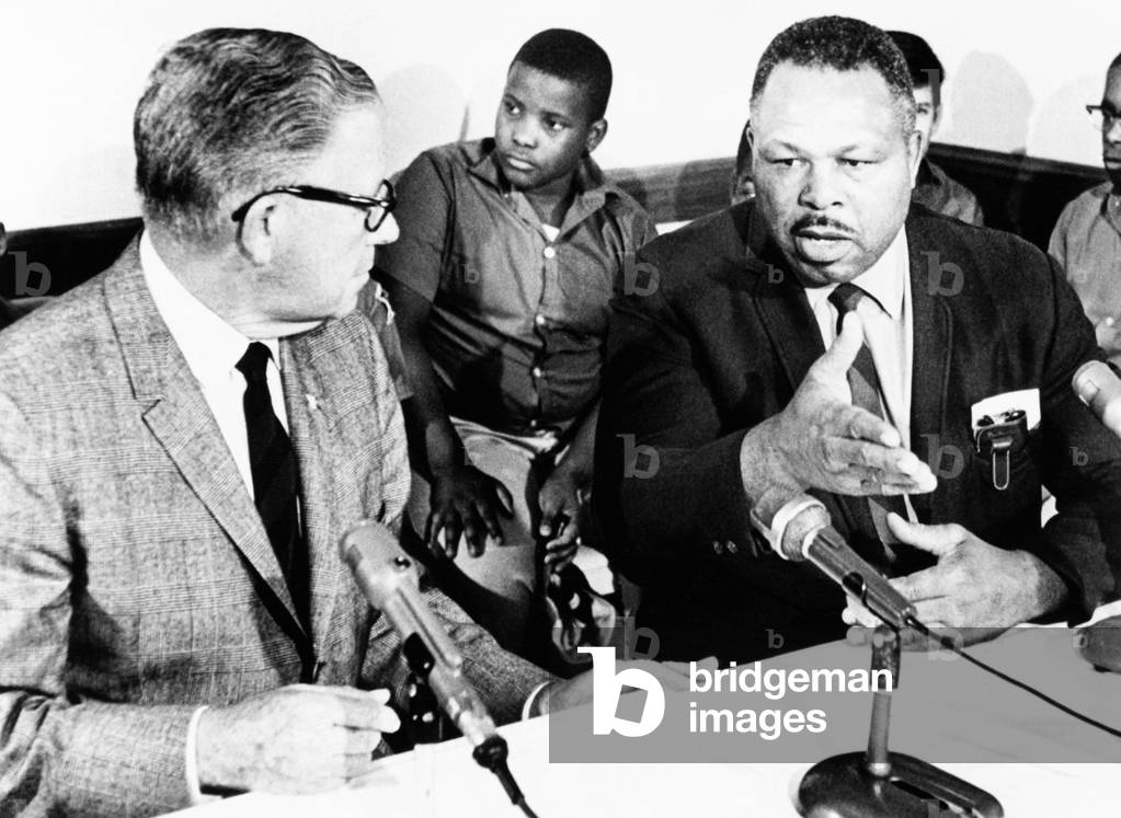 Former light heavyweight champion Archie Moore holds a Washington news conference. Sept. 20, 1967. Moore explained that in San Diego he helps African America youth avoid juvenile delinquency by learning 'to walk around trouble with dignity.' At left is Sen. George Murphy and in the background some of Moore's 'boys'