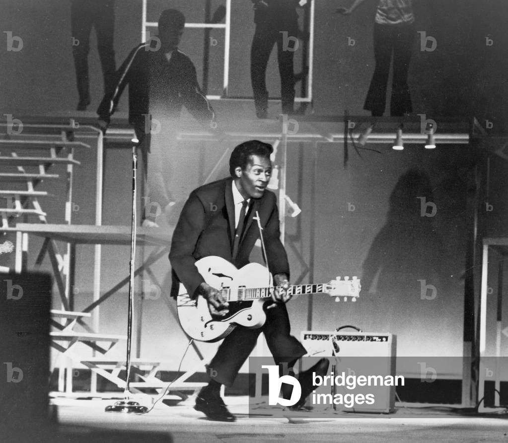 Chuck Berry (b. 1926) on stage, playing guitar. 1965