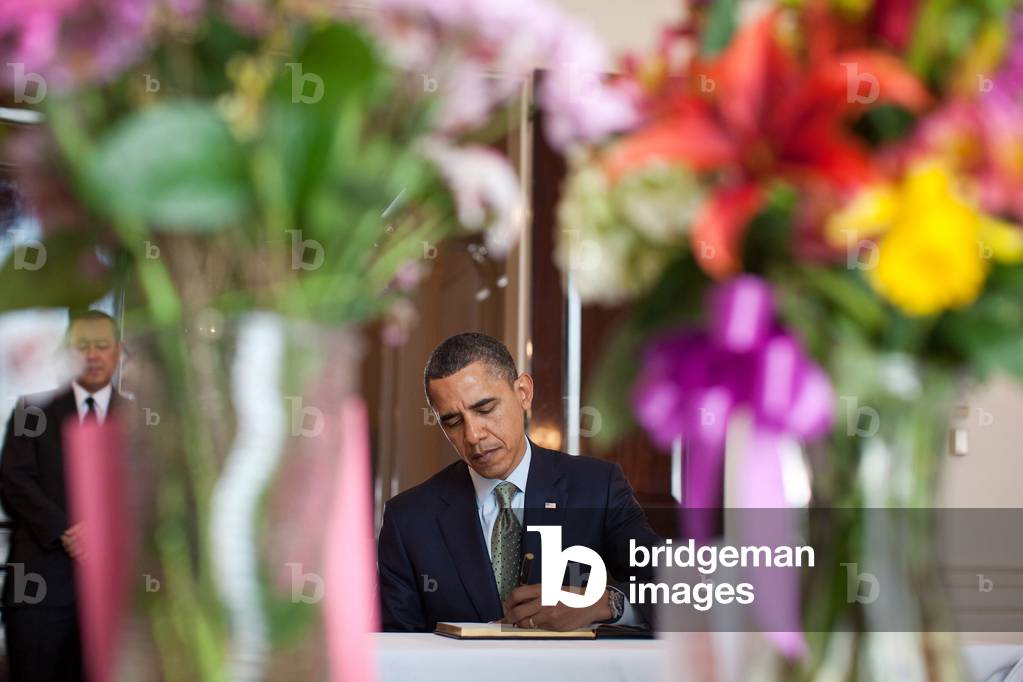 President Obama signs a condolence book for Japan's tsunami victims at the Japanese Embassy. Standing at left is Japanese Ambassador Ichiro Fujisaki. March 17 2011. (BSWH_2011_8_145)