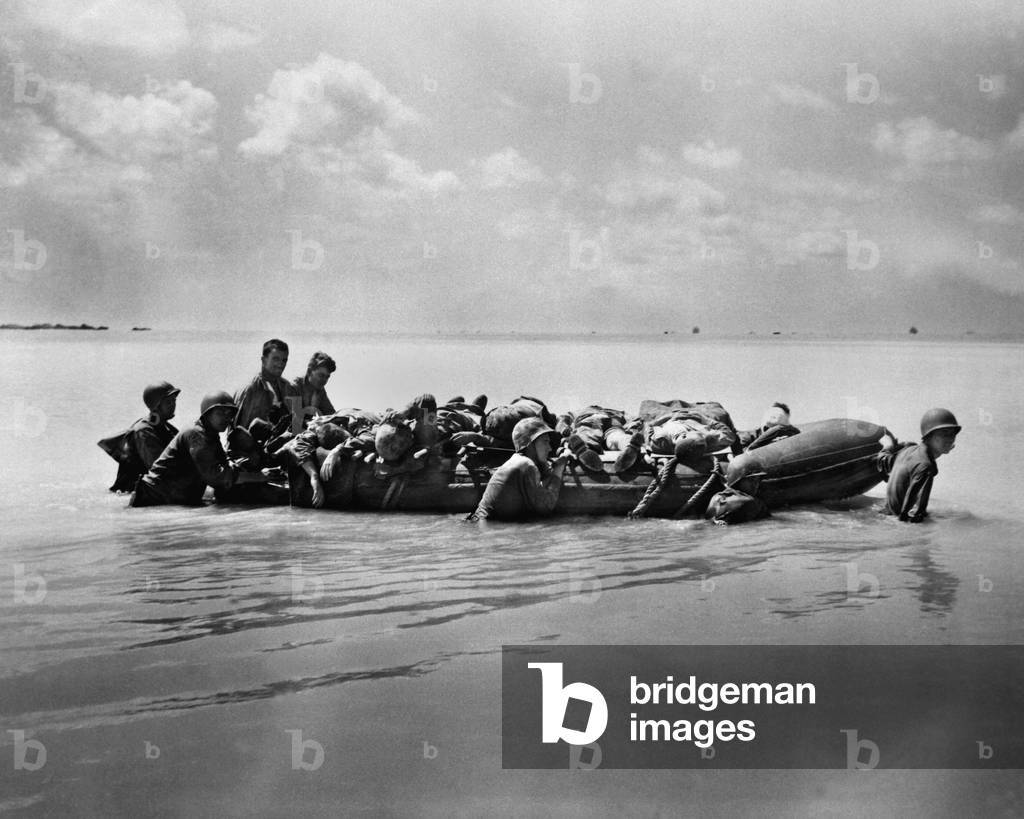 Wounded Marines in rubber boats are towed to larger vessels for transport to base hospitals. There were among the 2,296 wounded in the Battle of Tarawa against the Japanese, Nov. 20-23, 1943
