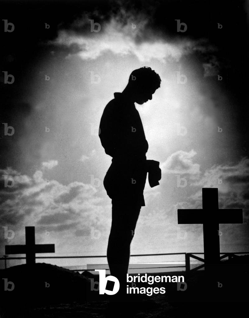 Coast Guardsman stands at a U.S. serviceman's grave in the Pacific. 1944 during World War 2