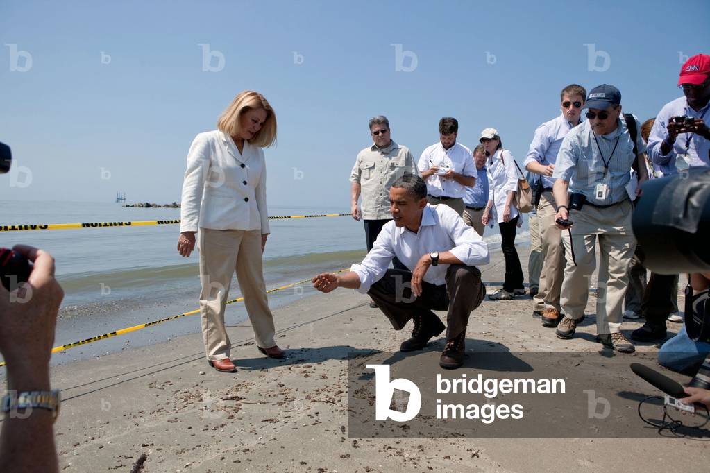President Obama inspects a tar ball on Fourchon Beach Louisiana with Lafourche Parish President Charlotte Randolf left . May 28 2010. (BSWH_2011_8_154)