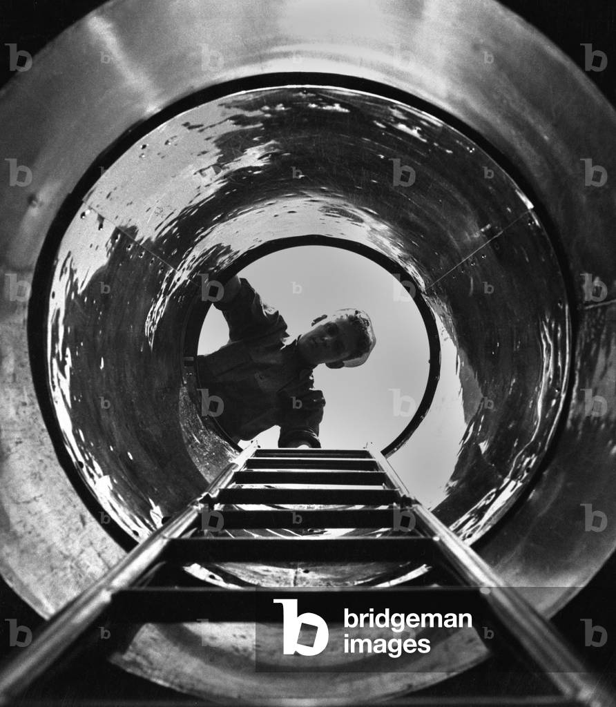 U.S. sailor looks down the hatch the submarine, USS MARLIN at New London, Conn. World War 2, August 1943