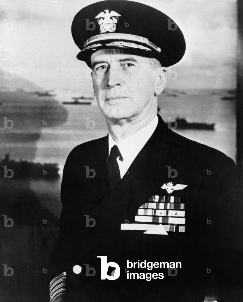 Admiral Ernest King in full naval uniform, against a backdrop of the fleet. 1956