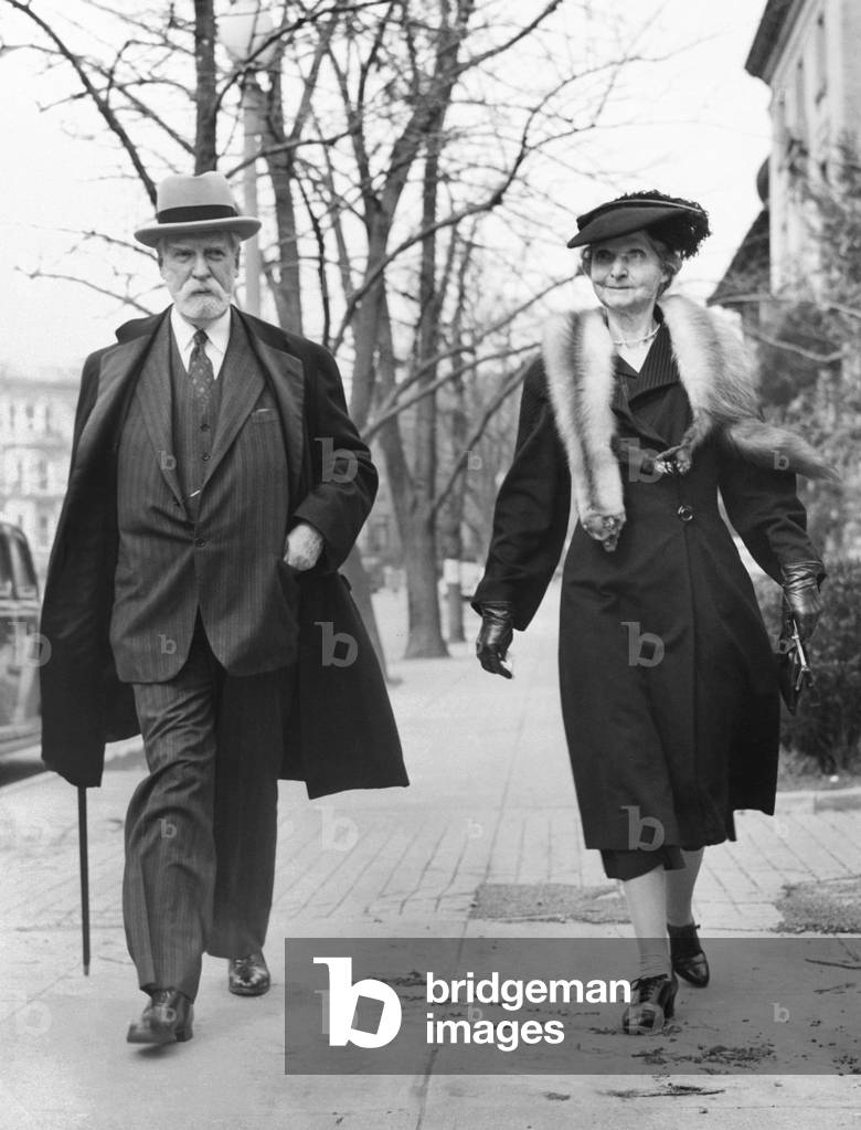Former Chief Justice Charles Evans Hughes and Antoinette Carter Hughes walk in Washington. Hughes was celebrating his 82nd birthday on April 11, 1944