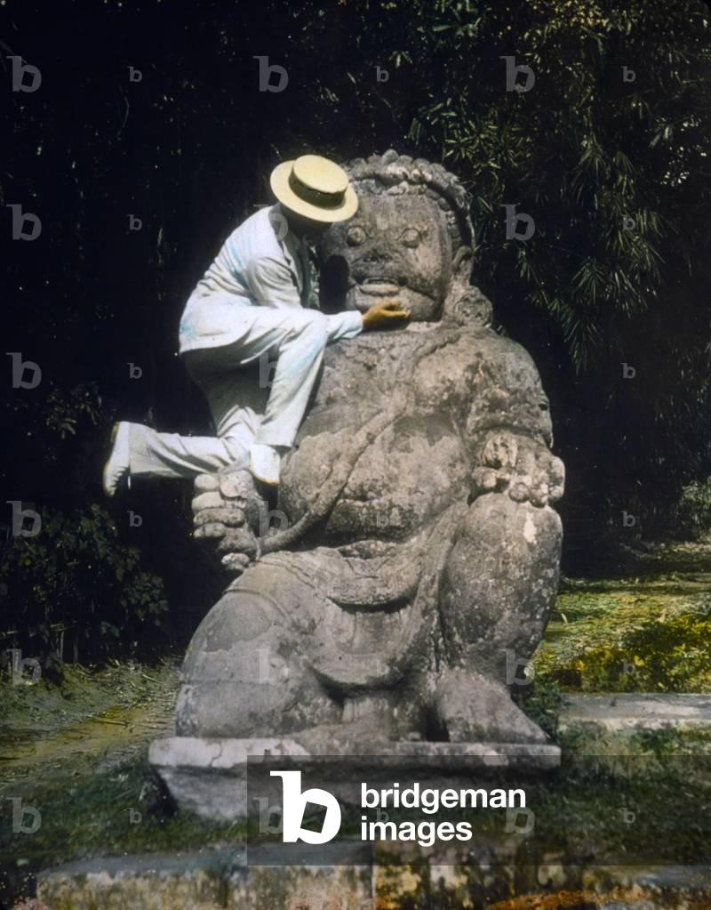 Indonesia, man in straw hat standing on Buddhist idol at ruins of Borobudur, hand colored lantern slide, photograph by William Henry Jackson, 1895