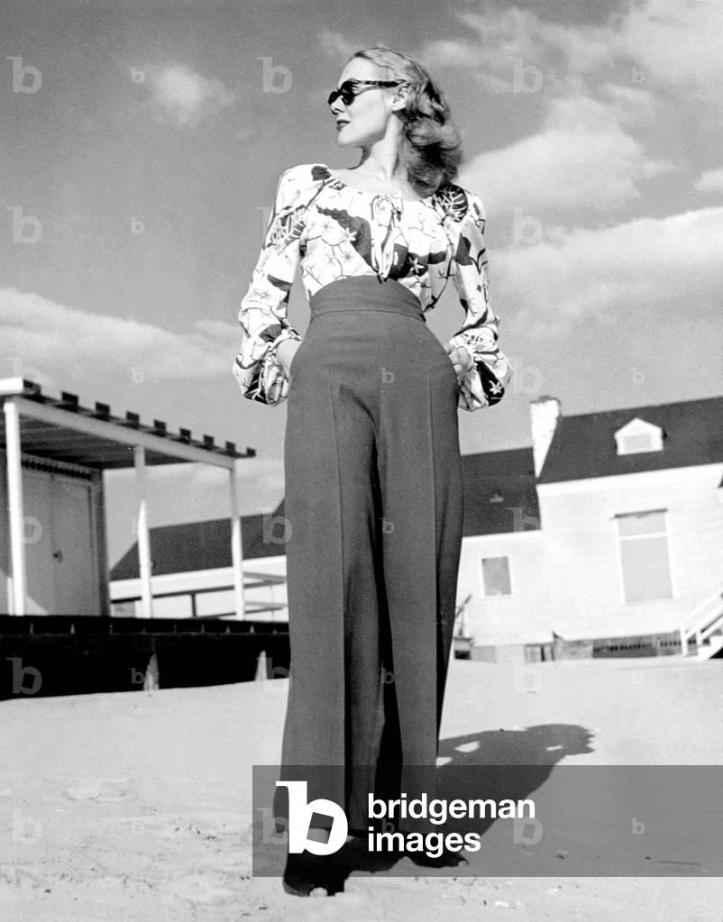 1940s Fashion: a peasant top with blousson sleeves and a tropical floral pattern with high-waisted pants, 1945.