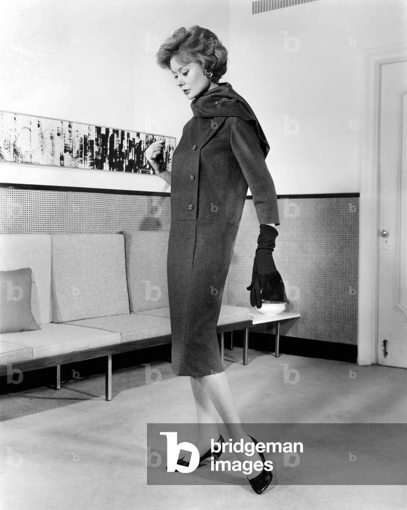 Below-the-knee trapezoid dress, also called the 'sack dress'. The 'sacks' lasted only a short time before, and the waist returned until the mid-1960s. July 1958