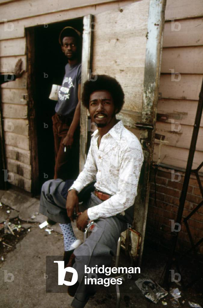 1970s Americ. Two young men at the entrance to a pool hall on the West Side of Chicago, c. 1973