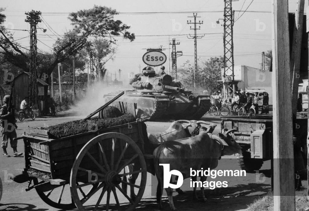Vietnam War. A US Army tank shares the streets of Saigon with ox carts during the second year of the US escalation of the war. 1966