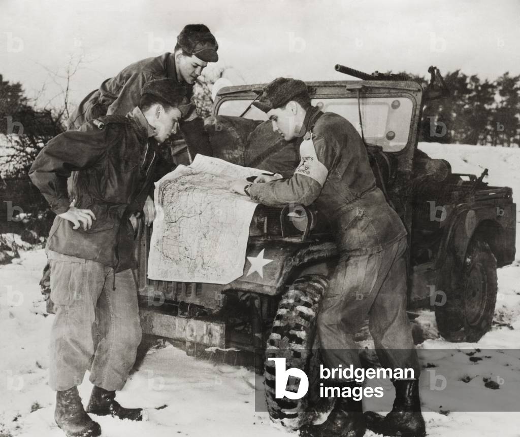 Elvis Presley and other soldiers read a map on maneuvers in Germany. He served with the with 1st Medium Tank Battalion, 3d Armored Division. c. 1959