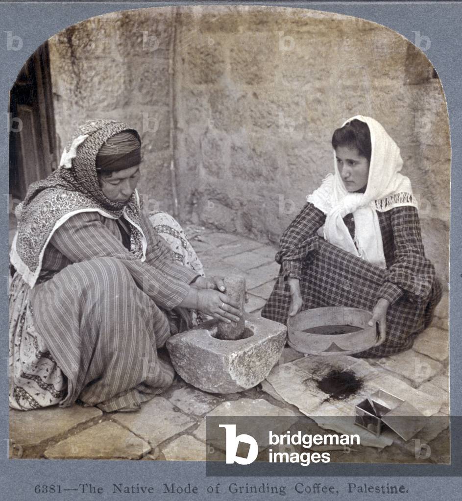 Palestine, two women seated, one with mortar & pestle, other with a sieve, original caption reads: 'The Native Mode of Grinding Coffee', c.1905