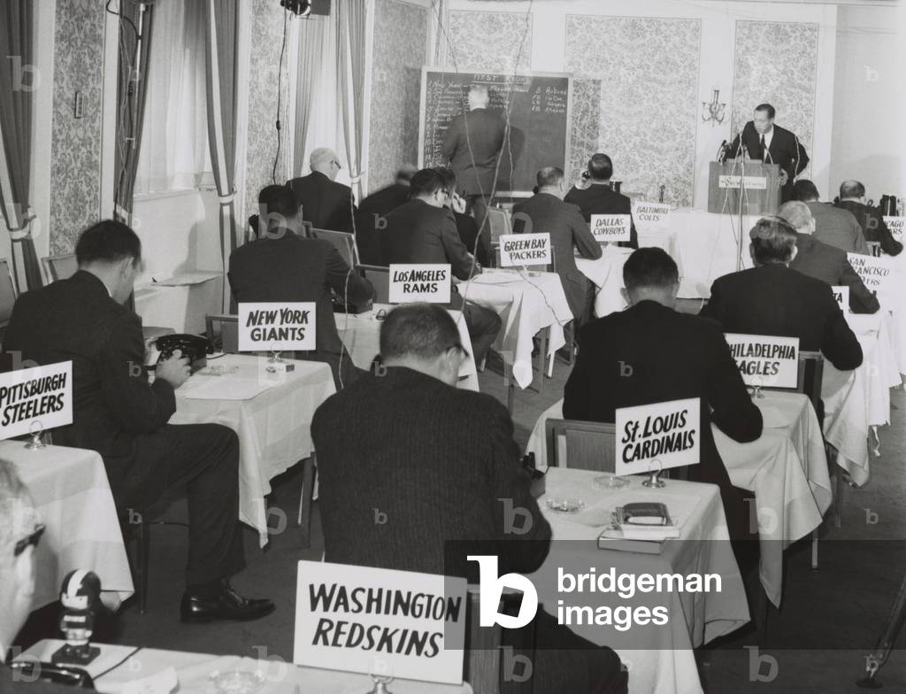 National Football League draft meeting in New York, Nov. 28, 1964. Commissioner Pete Rozelle reads the picks as representatives of the various football teams make their selections.
