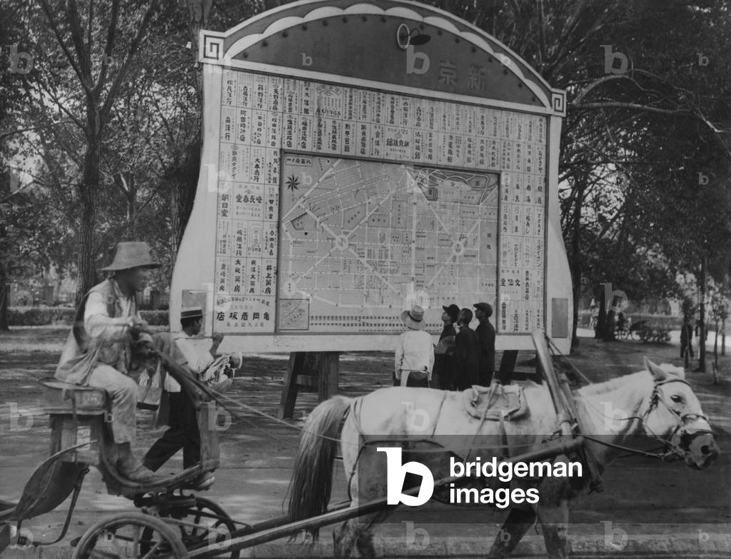 Horse drawn wagon passes billboard with Japanese plan for new city of Hsinking, Manchukuo. On the site of an old neglected town of Changchun, Hsinking (New Capital) had grown to 150,000 residents. It was planned to grow to 2 million, most expected to emigrate from the Japanese homeland. c. 1934