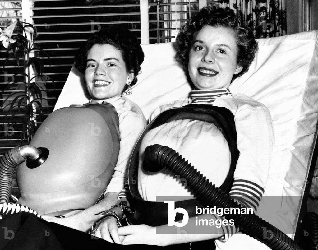 Two women polio victims using chest respirators that free them from the iron lung. Both were stricken in 1953. July 16, 1955
