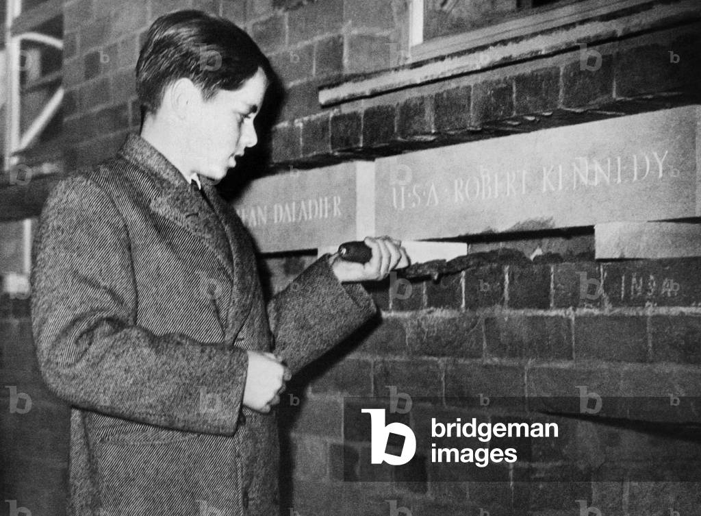 Robert Kennedy, one of several children of 'Distinguished Foreigners', laying commemorative stones at Clubland, a new youth center in London. Apr. 14, 1939