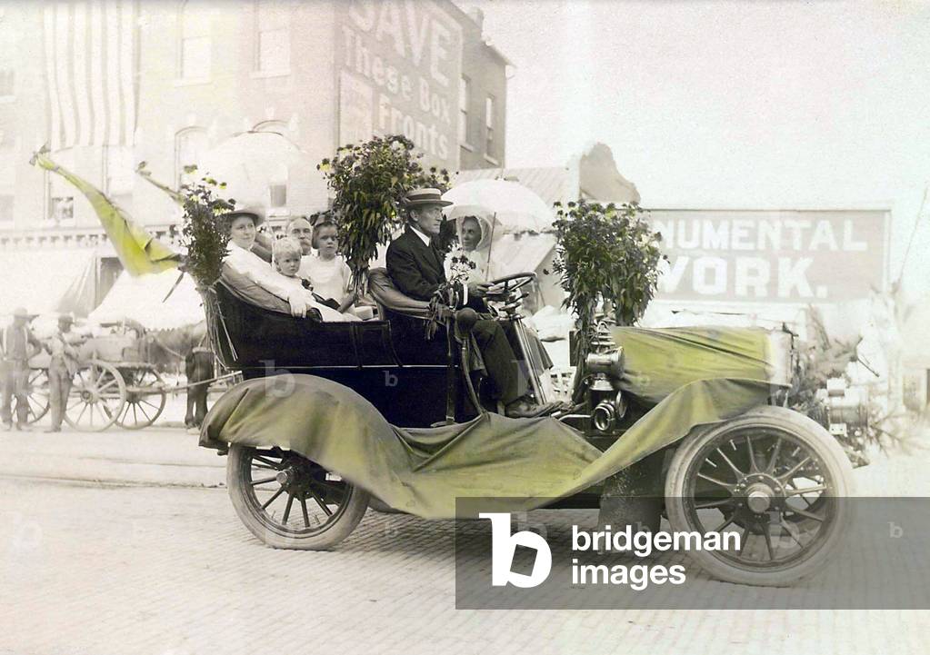 Cars. Geneva Automobile Parade. Firemen's parade, Anne Fitzhugh Miller and Mr. and Mrs. Graves ride in Geneva Political Equality Club auto decorated with yellow chrysanthemums and bunting to receive honorable mention. Geneva, NY, August 6, 1909