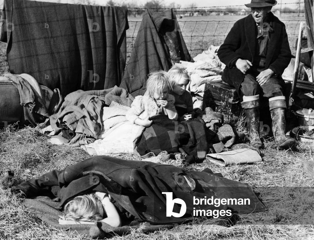 A Misouri sharecropper with his three little children sit with their posessions on the edge of a state highway after being evicted from their home. c. 1939