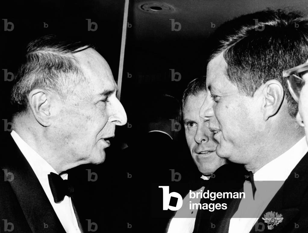President Kennedy talks with Gen. Douglas MacArthur (left). They were at the National Football Hall of Fame dinner at the Waldorf Astoria. In his speech, the President lamented that America's number one national sport seems to be sitting and watching somebody else get exercise. Dec. 5, 1961
