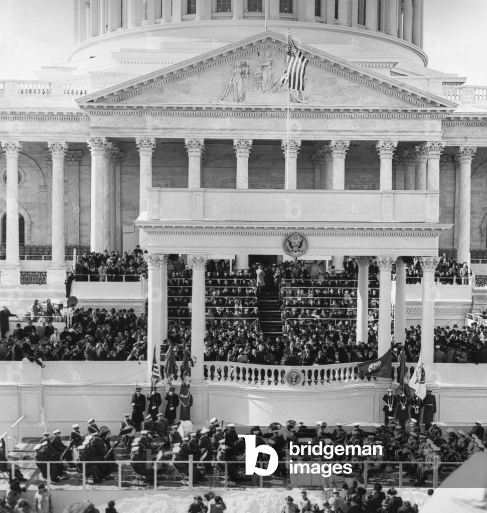 Inauguration of John Kennedy at East Portico, U.S. Capitol Building. President John F. Kennedy delivering his Inaugural Address. Looking on: Vice President Lyndon Johnson; Richard Nixon; Harry Truman; Bess Truman; Dwight Eisenhower; Mamie Eisenhower; First Lady Jacqueline Kennedy; Lady Bird Johnson; Joseph Kennedy, Sr.; and Rose Fitzgerald Kennedy. United States Marine Band on platform below the Inaugural stand.