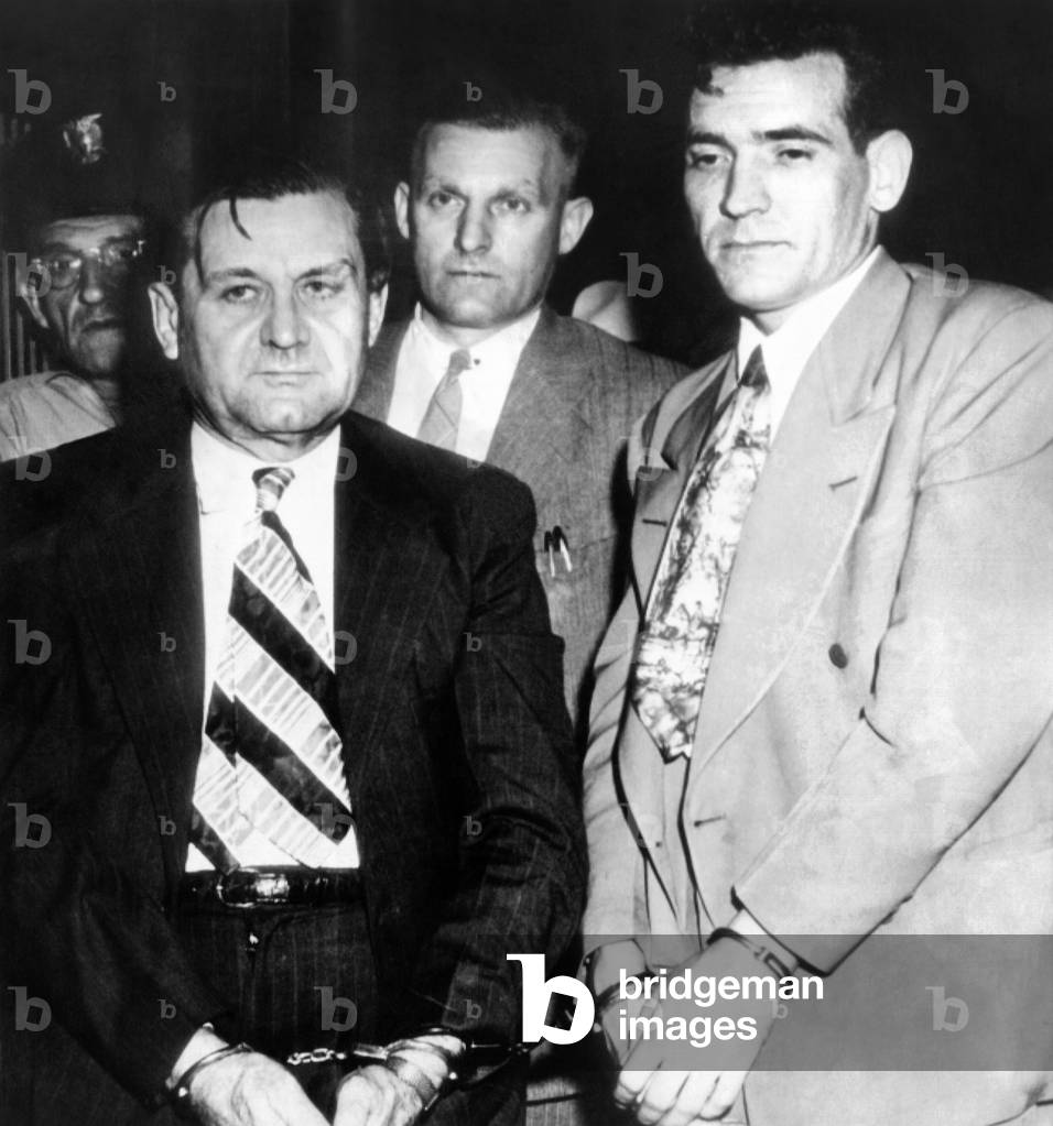 George 'Bugs' Moran and Virgil Summers, booked at Dayton, Ohio, for a ,000 holdup of a local tavern. Behind are local police, in center, Detective C.M. Teeter. July 12, 1946