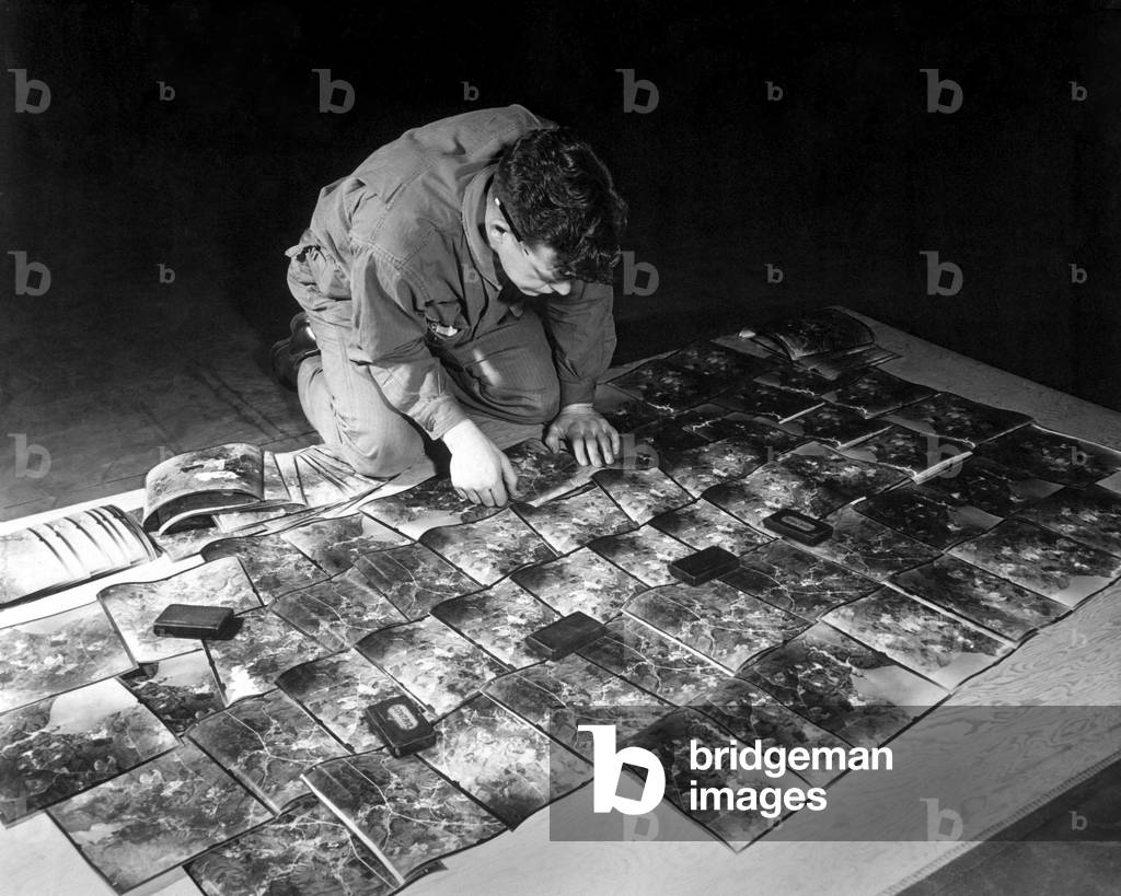 World War 2 Strategic planning for the invasion of Europe. U.S. Army engineer laying out the aerial photographs. Kew Gardens, England, Jan. 11, 1943