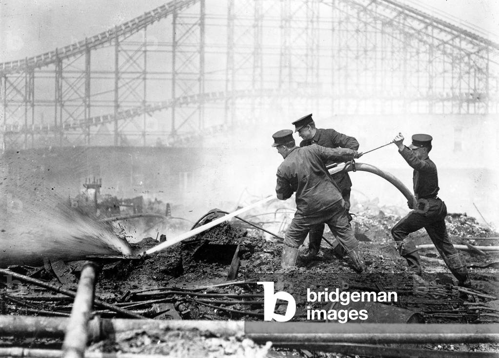 Coney Island, the Dreamland fire, men extinguishing the fire at Dreamland, roller coaster in background, Coney Island, New York, photograph, 1911