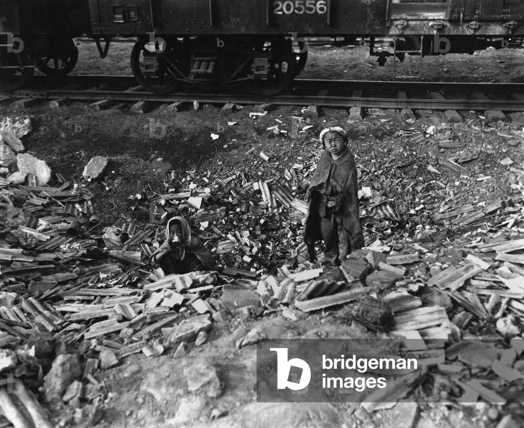 Homeless, possibly orphaned, brother and sister search empty cans for food. Seoul, Korea, railroad yards. November 17, 1950. Korean War, 1950-53
