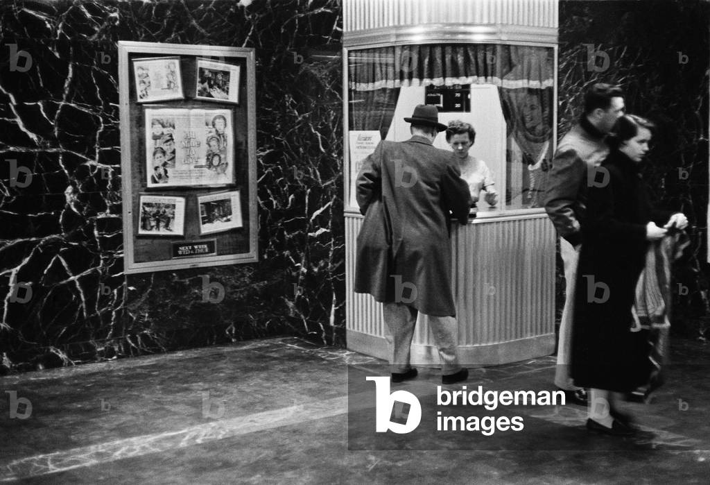 Man purchasing a movie ticket for the film. The coming attraction is the film, ALL MINE TO GIVE. Feb. 9, 1958.