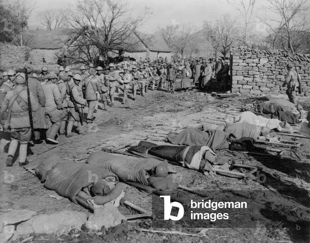Chinese Civil War 1946-1949. Chinese Nationalist soldiers heading to the Su Zhou (Soochow) front, Dec. 2, 1948. In the other direction are wounded soldiers returning from battle, and other casualties lying on stretchers in the foreground.