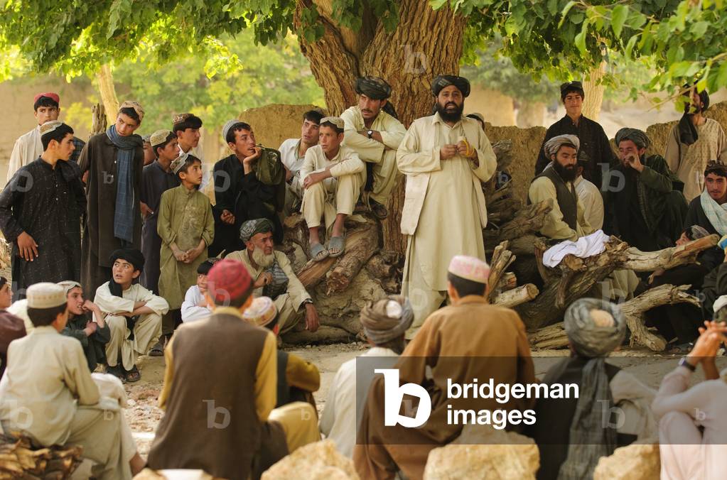 District chief Abdul Qayum center speaks to Afghan elders during a shura in Zabul province Afghanistan. Qayum discussed security in the district and the upcoming parliamentary elections. Sept. 8 2010., Photo by:Everett Collection