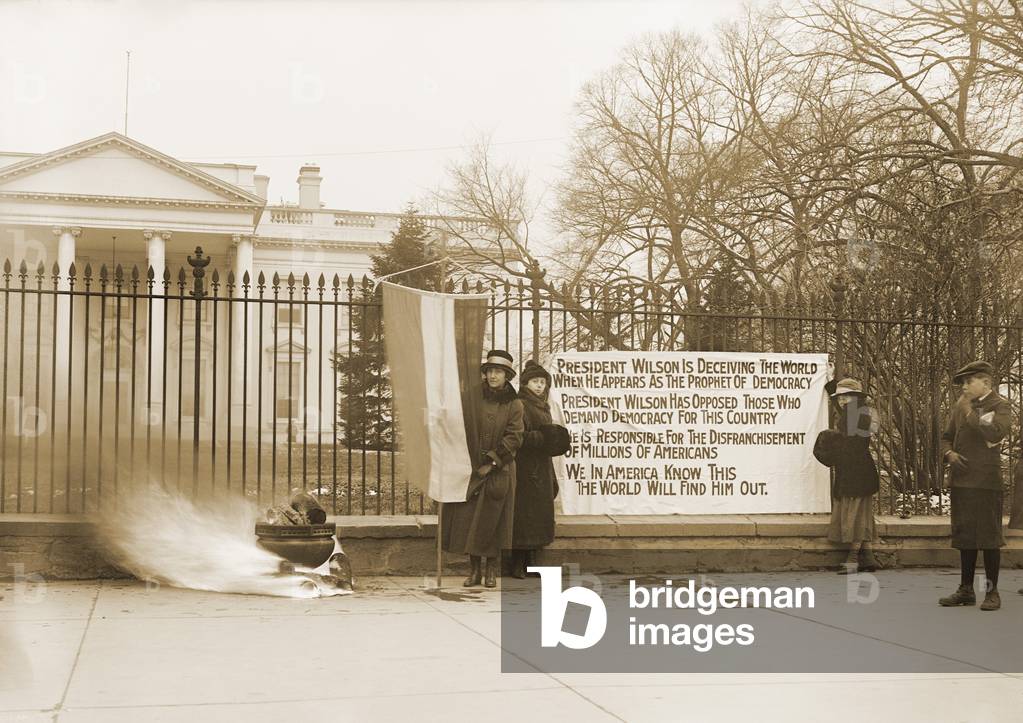 National Women's Party demonstration with a bonfire in front of the White House in 1918. The banner questions Wilson's commitment to democracy for his failure to support women's suffrage
