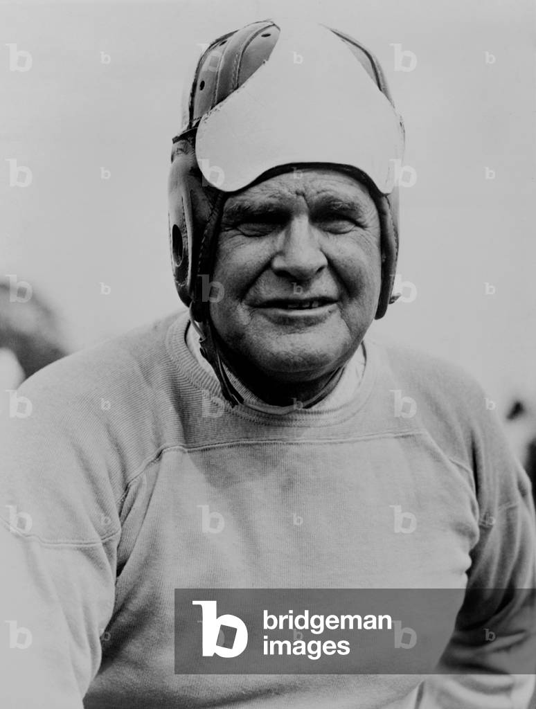 Coach Glenn 'Pop' Warner, wearing football headgear, 1933. Warner was in his first year as coach of Temple University