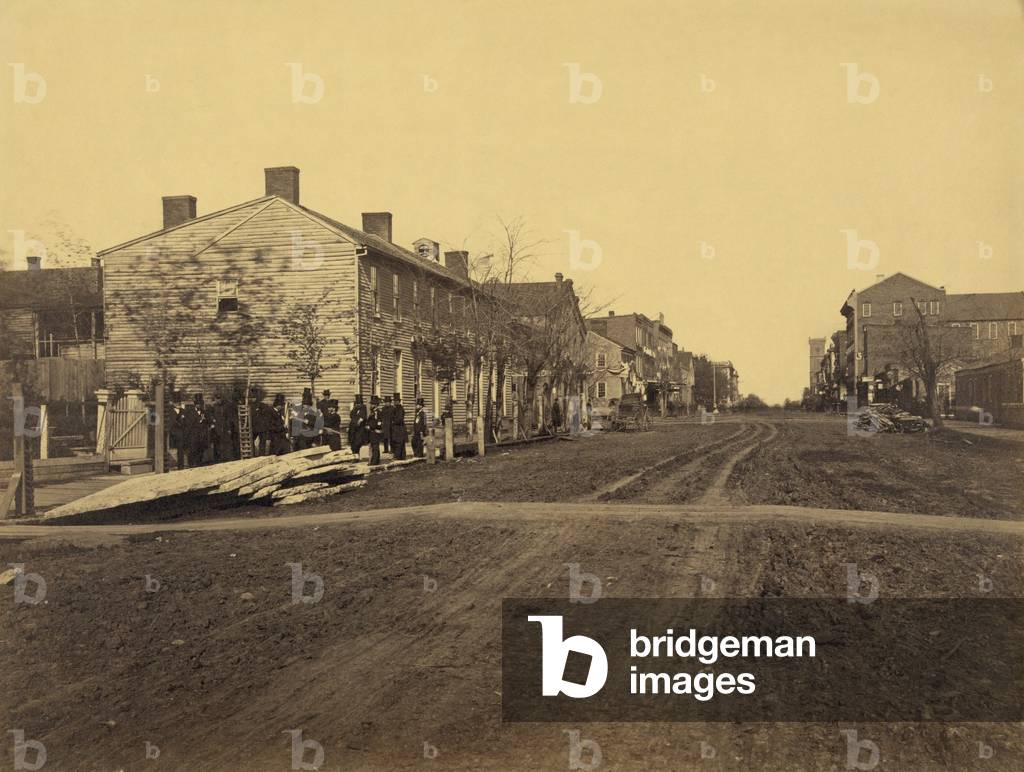 Men standing near the site of the Globe Tavern, the residence of Lincoln's family, during the first year (1842-43) of his marriage to Mary Todd, in Springfield, Illinois. It was a single room on the second floor of a rooming house where Mary gave birth to their first child,- Robert Todd Lincoln. 1865 photograph by Samuel Fassett