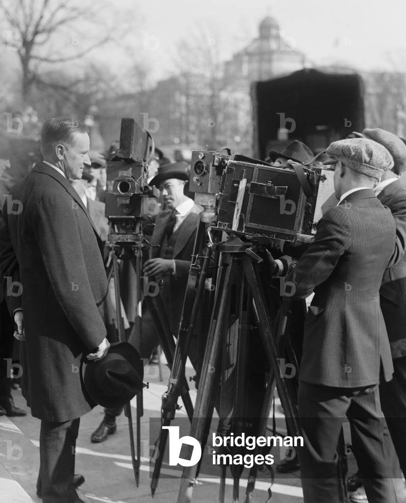 President Calvin Coolidge stands in front of newsreel cameras. 1921 in Washington, D.C