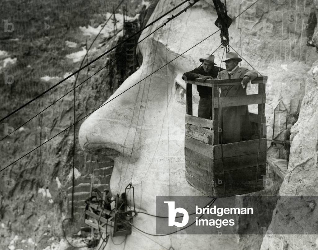Gutzon Borglum and his son, Lincoln, in the Mt. Rushmore tramway, Nov. 23, 1935. The Jefferson sculpture is tasking it's finished form behind them. Photo by Charles d'Emery
