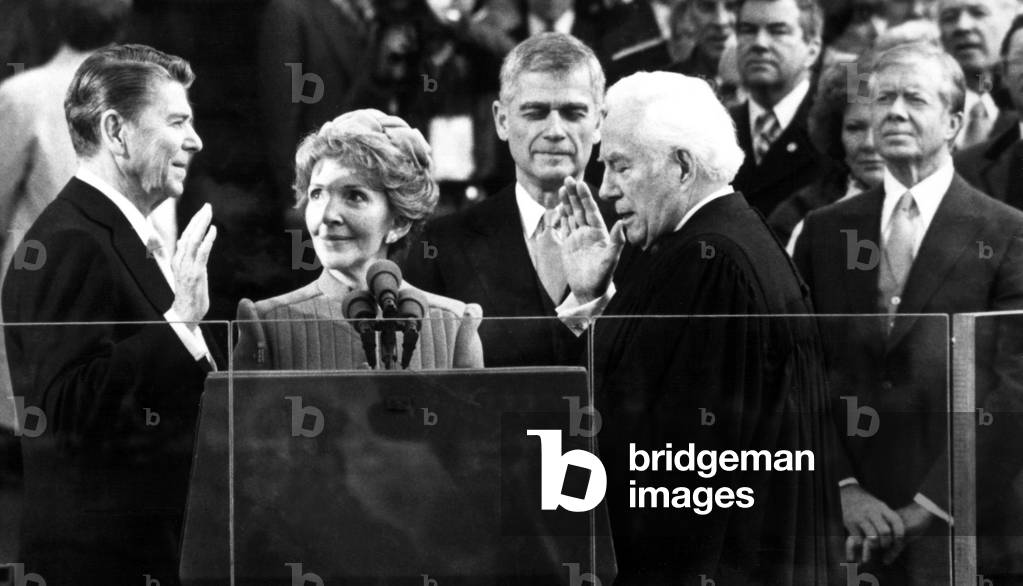 Ronald Reagan sworn in as president by Chief Justice Warren Burger as Nancy Reagan, Senator Mark Hatfield, President Jimmy Carter look on, 1/20/81