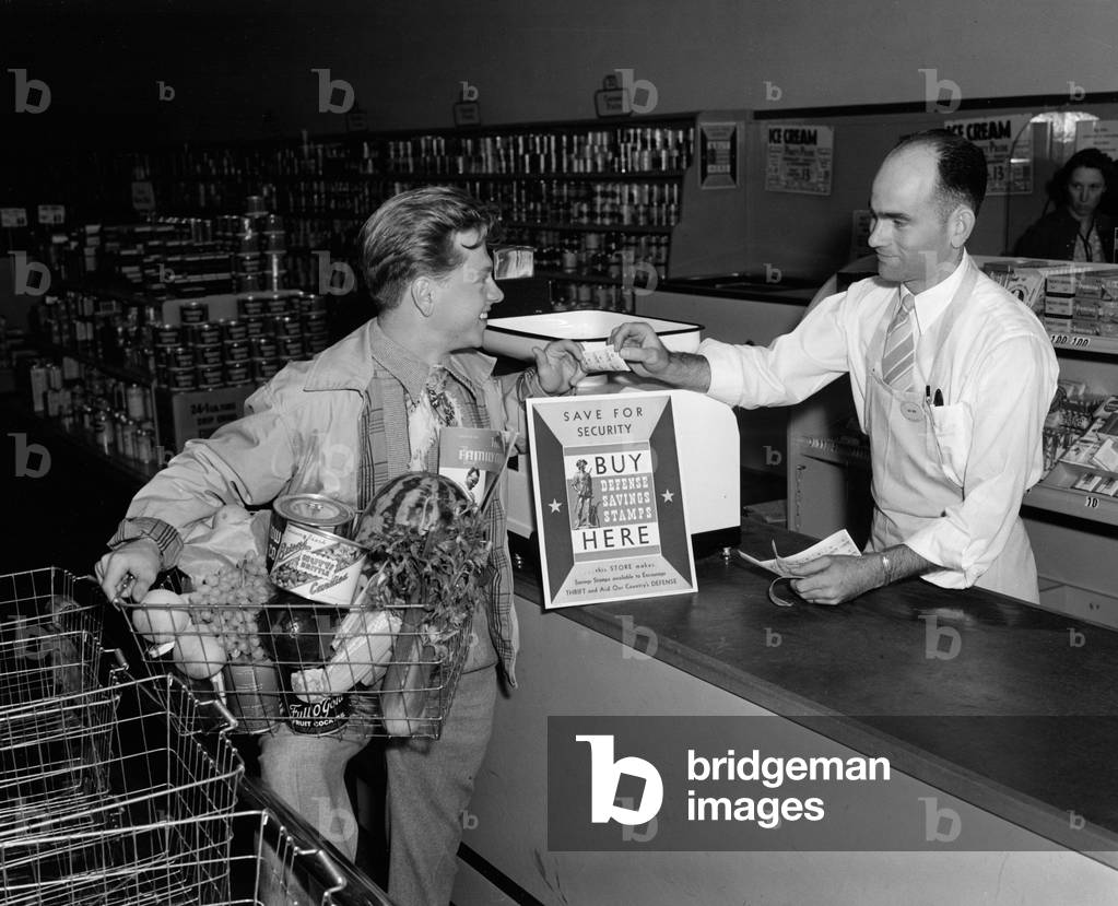Mickey Rooney paying for his groceries with Defense Savings Stamps in World War II publicity photo