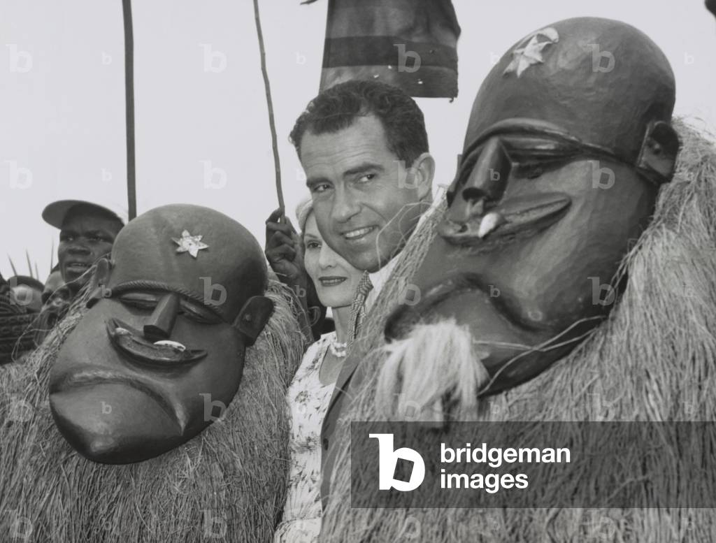 Vice President Richard Nixon standing among Liberian dancers. Underneath the traditional costumes and masks are Goa Devil Dancers. Pat Nixon is partially obscured. March 13, 1957