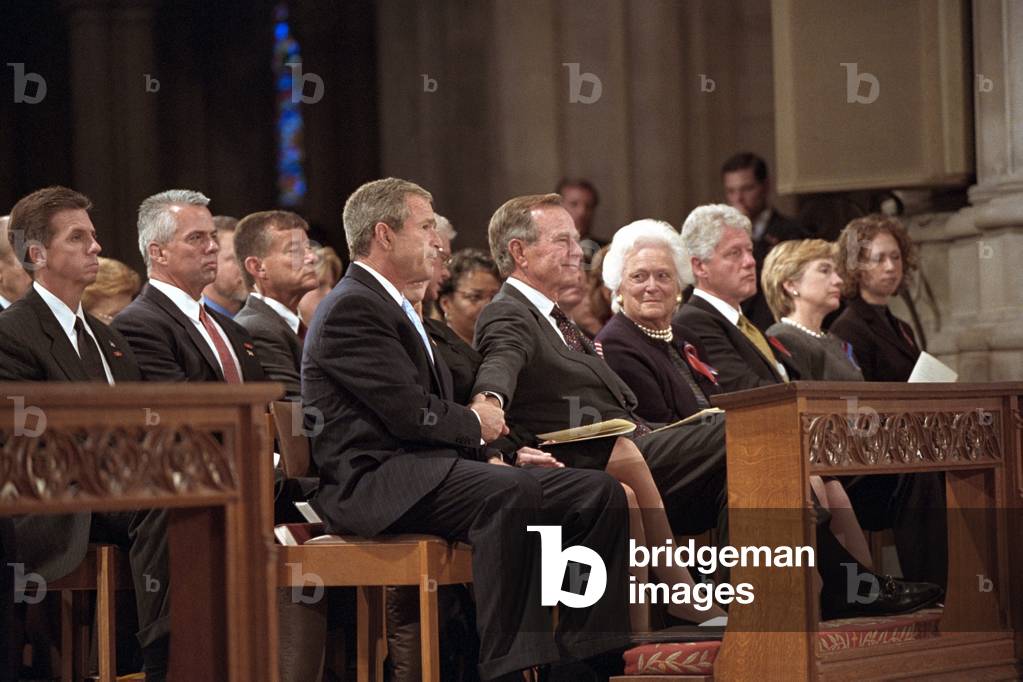 President George W. Bush grasps the hand of his father, former President George H. W. Bush during the service for the victims of the 9-11 Terrorist Attacks, 2001 (photo)