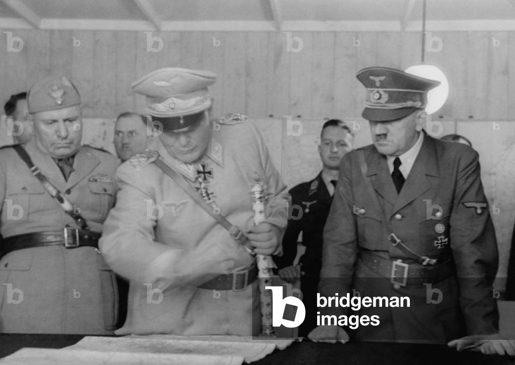 Adolf Hitler, Hermann Goering, and Benito Mussolini looking at map, August 26, 1941. German military officers standing behind them, at Anlage Sud (Installation South) Strzyzow, Poland