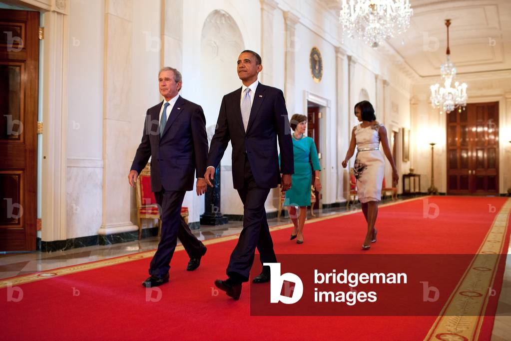 President Barack Obama and First Lady Michelle Obama walk with former President George W. Bush and former First Lady Laura Bush in the Cross Hall towards the East Room of the White House, May 31, 2012. The President and First Lady hosted a ceremony to unveil the Bushes' official portraits, which will be displayed in the White House.