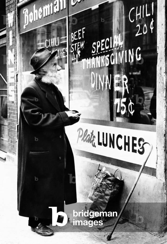 Chicago homeless man on Thanksgiving, 1952. He can't afford the fancy 75-cent special posted on the window of a West Madison Street café, and will settle for the 20-cent bowl of chili instead