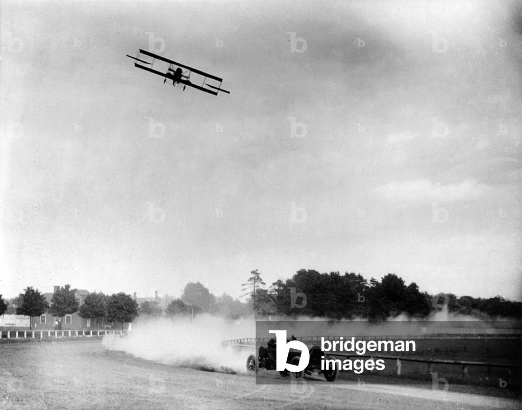 Cars. Race between Lincoln Beechey in airplane and Barney Oldfield in automobile, going around race track, June, 28 1912