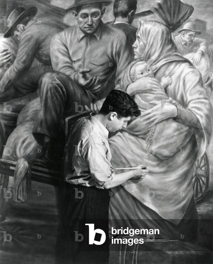 Edward Leaning painting a WPA mural at Ellis Island, c. 1937. The mural depicts the role of immigrants to the industrial development of America
