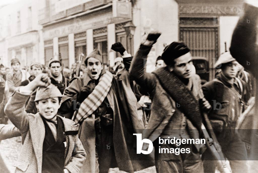 Battalion of Republican (anti-Franco) shock troops marching in Madrid during Spanish Civil War, Madrid. They make the clenched fist salute of solidarity. c. 1937