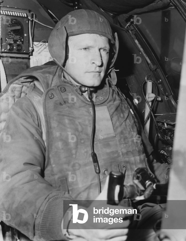 Air Force pilot at the controls of his B-29 just prior to take-off on a mission in North Korea. He wears 105 pounds of flight gear necessary for combat missions. Korean War, 1950-53