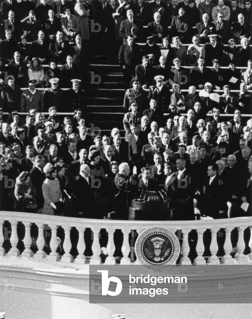 President John Kennedy takes the oath of office administered by Chief Justice Earl Warren. Jan. 20, 1961.
