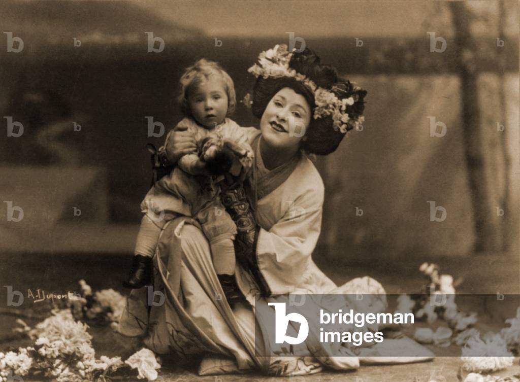 Geraldine Farrar (1882-1967), kneeling child on knee, in role of Cio-Cio San in Puccini's opera, MADAME BUTTERFLY. 1908